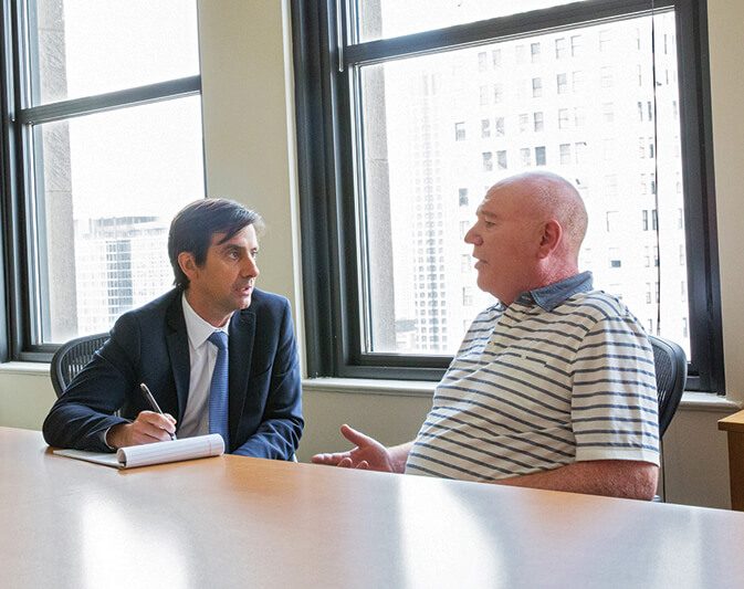 Chicago SSI lawyer Lawrence Mabes, left, speaks with a client, Pat, in the offices of Nash Disability Law.